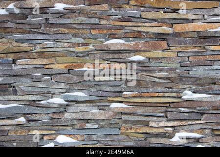 travertine texture of stone covering the walls of the house. Stock Photo