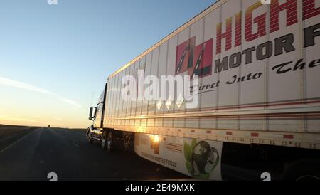 Semi truck rolling down toward the sunset on Interstate 80, Indiana Stock Photo