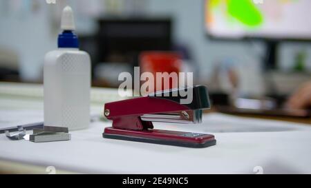 Office desk, stapler on the desk and glue in a tube, staples for the stapler. Office tools. Stock Photo