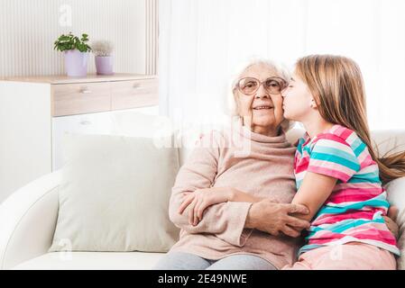Granddaughter lovely kissing and hugging grandmother Stock Photo