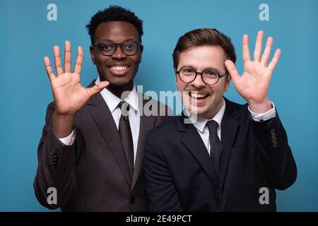 Two caucasian and african men saying hello, waving a hand. Welcome home sign Stock Photo