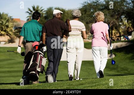 Friends Walking on Golf Course Stock Photo