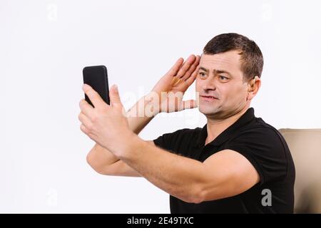 Caucasian senior man talking by video call using non-verbal gestures. White background. Stock Photo