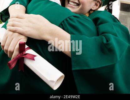Graduates Hugging after ceremony Stock Photo