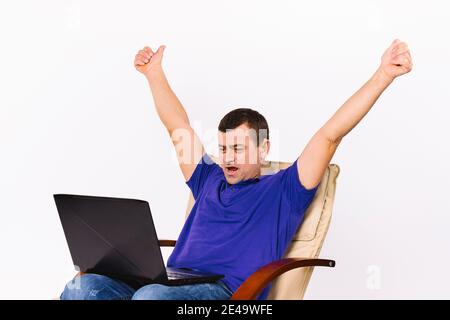 A man with a laptop raised both hands up. Video communication using sign gestures. White background. Stock Photo