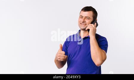 Banner,long format. A man is talking on a cell phone and showing thumb up to the camera. White background with empty space. Stock Photo