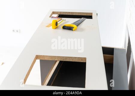 to cut holes in the kitchen countertop for equipment Stock Photo