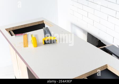 to cut holes in the kitchen countertop for equipment Stock Photo