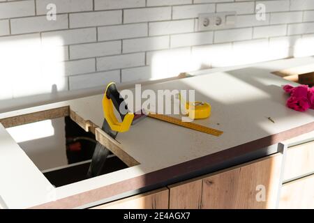 to cut holes in the kitchen countertop for equipment Stock Photo