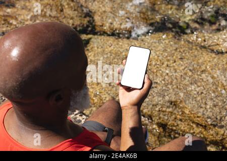 Senior african american man using smartphone by the sea Stock Photo