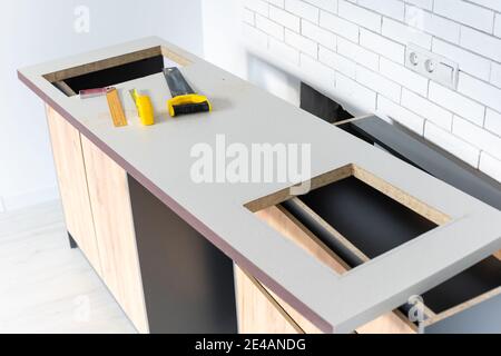 to cut holes in the kitchen countertop for equipment Stock Photo