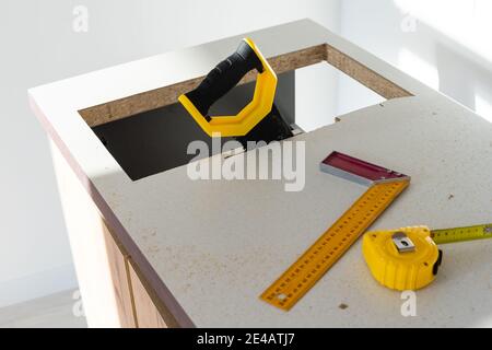 to cut holes in the kitchen countertop for equipment Stock Photo