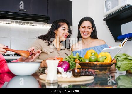 latin women cooking vegetables food and having fun in a mexican kitchen in Mexico city Stock Photo