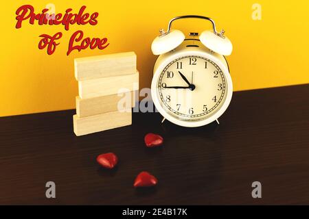 Principles of love conceptual photo banner with copy space, place for text and red hearts, wooden pegs, blocks, and alarm clock photo Stock Photo