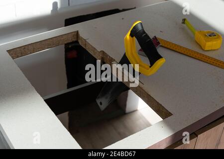 to cut holes in the kitchen countertop for equipment Stock Photo