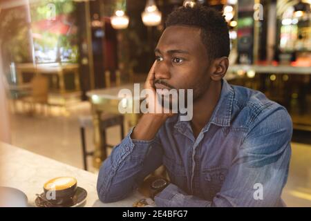 African american man sitting in a cafe drinking a cup of coffee Stock Photo