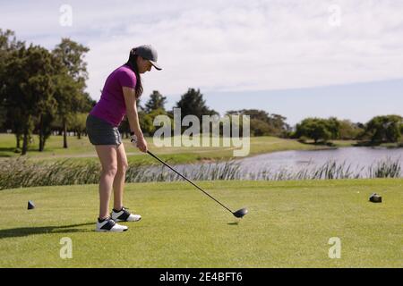 Caucasian woman playing golf swinging club and taking a shot Stock Photo