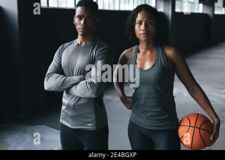 African american man and woman standing in an empty urban building looking at camera Stock Photo