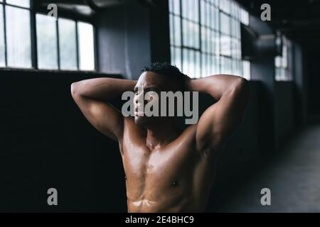 African american man standing and flexing his muscles in empty urban building Stock Photo