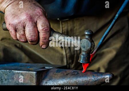 Blacksmith Ralph Oalmann manipulates a heated piece of metal in his shop at Fort Gaines, Aug. 5, 2017, in Dauphin Island, Alabama. Fort Gaines frequen Stock Photo