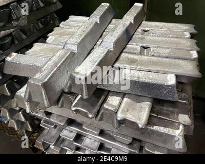 aluminum alloy ingots stacked in the foreground, ready for casting, raw material Stock Photo