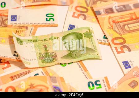 Fifty euro money banknotes background texture and Mao Zedong portrait on 1 Chinese paper currency Yuan renminbi in close up Stock Photo