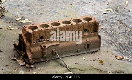 An old disintegrating rusting engine block lying in the dirt Stock Photo