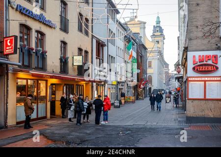 Duesseldorf, North Rhine-Westphalia, Germany - Empty old town of Duesseldorf with Santa Claus in times of the corona crisis during the second part of lockdown, passers-by eat their takeaway pizza on the street.
