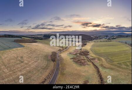 Germany, Thuringia, Großbreitenbach, Allersdorf, scenery, road, fields, village in the background, mountains, morning mood, aerial view Stock Photo