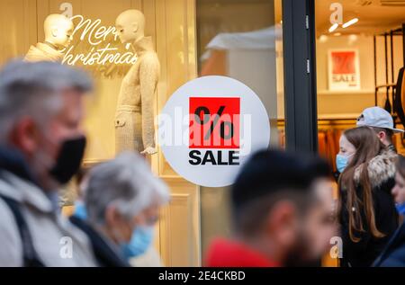 Essen, Ruhr area, North Rhine-Westphalia, Germany - shop window of a fashion store at Christmas time with special offers, passers-by with protective masks in Essen city center in times of the corona crisis during the second part of the lockdown. Stock Photo