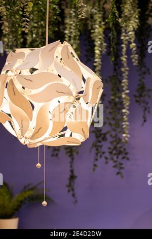 Beautiful white geometric modern ceiling lamp interior contemporary decoration isolated on a dark background.Loft ceiling design. Live plants in Stock Photo