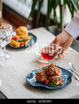 Table served with pastry desserts and tea Stock Photo