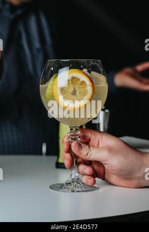 Cocktails with champagne in wine glasses on the bar table in the pub or restaurant with the bartender. Stock Photo