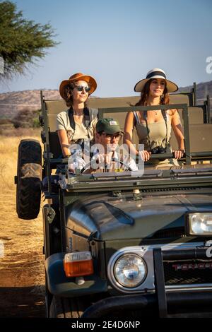 Guide drives two female guests through savannah Stock Photo