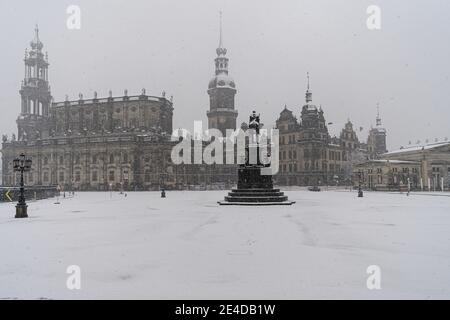 Dresden, Germany. 23rd Jan, 2021. It snows in the morning on the Theaterplatz with the Hofkirche (l-r), the Hausmannsturm, the equestrian statue of King Johann, the Residenzschloss and the Schinkelwache. Credit: Robert Michael/dpa-Zentralbild/dpa/Alamy Live News Stock Photo