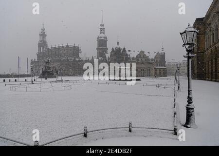 Dresden, Germany. 23rd Jan, 2021. It snows in the morning on the Theaterplatz with the Hofkirche (l-r), the equestrian statue of King Johann, the Hausmannsturm, the Residenzschloss, the Schinkelwache and the Zwinger. Credit: Robert Michael/dpa-Zentralbild/dpa/Alamy Live News Stock Photo