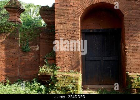 One of the gates of the Kasepuhan Cirebon palace which is made of wood and has red brick walls Stock Photo