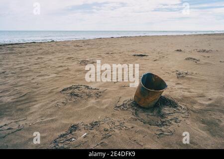 plastic pail washed up on a beach. You see the environmental problem with plastic in the world Stock Photo