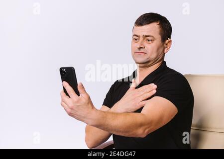 Senior hard of hearing man communicates via video call using non-verbal gestures. White background. Stock Photo