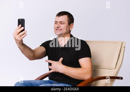 Smiling deaf senior man communicating by video call using sign language over white background. Stock Photo
