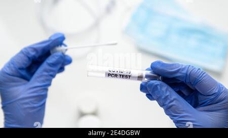 Test to coronavirus in doctor hands, nurse holds tube of COVID-19 swab collection kit in laboratory. Concept of corona virus diagnostics, nasal and or Stock Photo