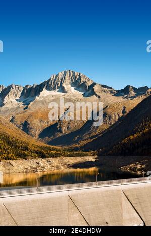 Peak of Care Alto (3462 m) and Bissina dam in the National Park of Adamello Brenta. Trentino Alto Adige, Italy Stock Photo