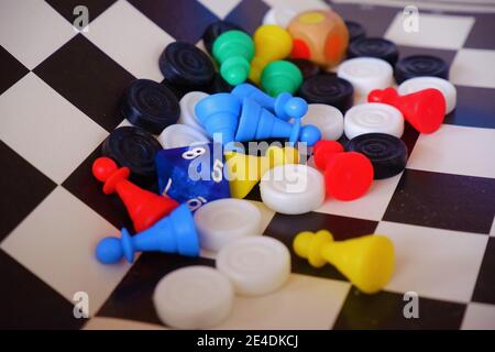 Different social board game figures on a checkered chessboard board Stock Photo