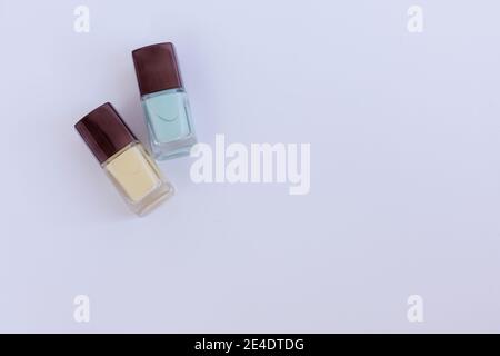 Collection of multi-colored bottles of nail polish. Layout for design on a gray background and a wooden table. Stock Photo