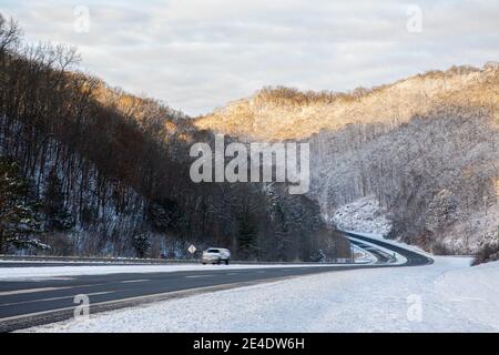 A rural, mountainous road winds through the Appalachian foothills of Eastern Kentucky in winter. Stock Photo