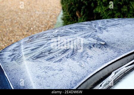 A thick, patterned, frost on the windscreen and bonnet (hood) of a blue Ford Mondeo car. Stock Photo