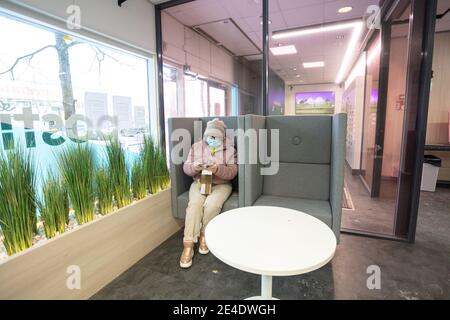 Espoo, Finland, January 9, 2021. A woman in a medical mask, she is in a contactless office at the post office, checking her parcel. High quality photo Stock Photo