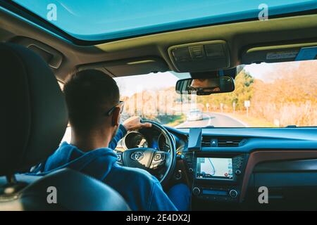 Young man driving Toyota car. Man using navigation system while driving a car. Lisbon, Portugal. 15.01.2021 Stock Photo