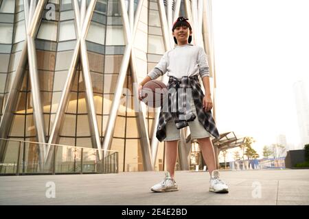 low angle outdoor portrait of a fifteen-year-old asian teenage basketball player Stock Photo