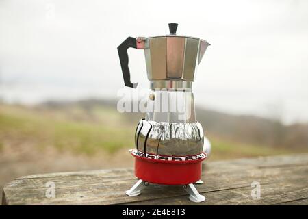 Making camping coffee from a geyser coffee maker on a gas burner,, autumn  outdoor. Male prepares coffee outdoors, travel activity for relaxing,  bushcr Stock Photo - Alamy